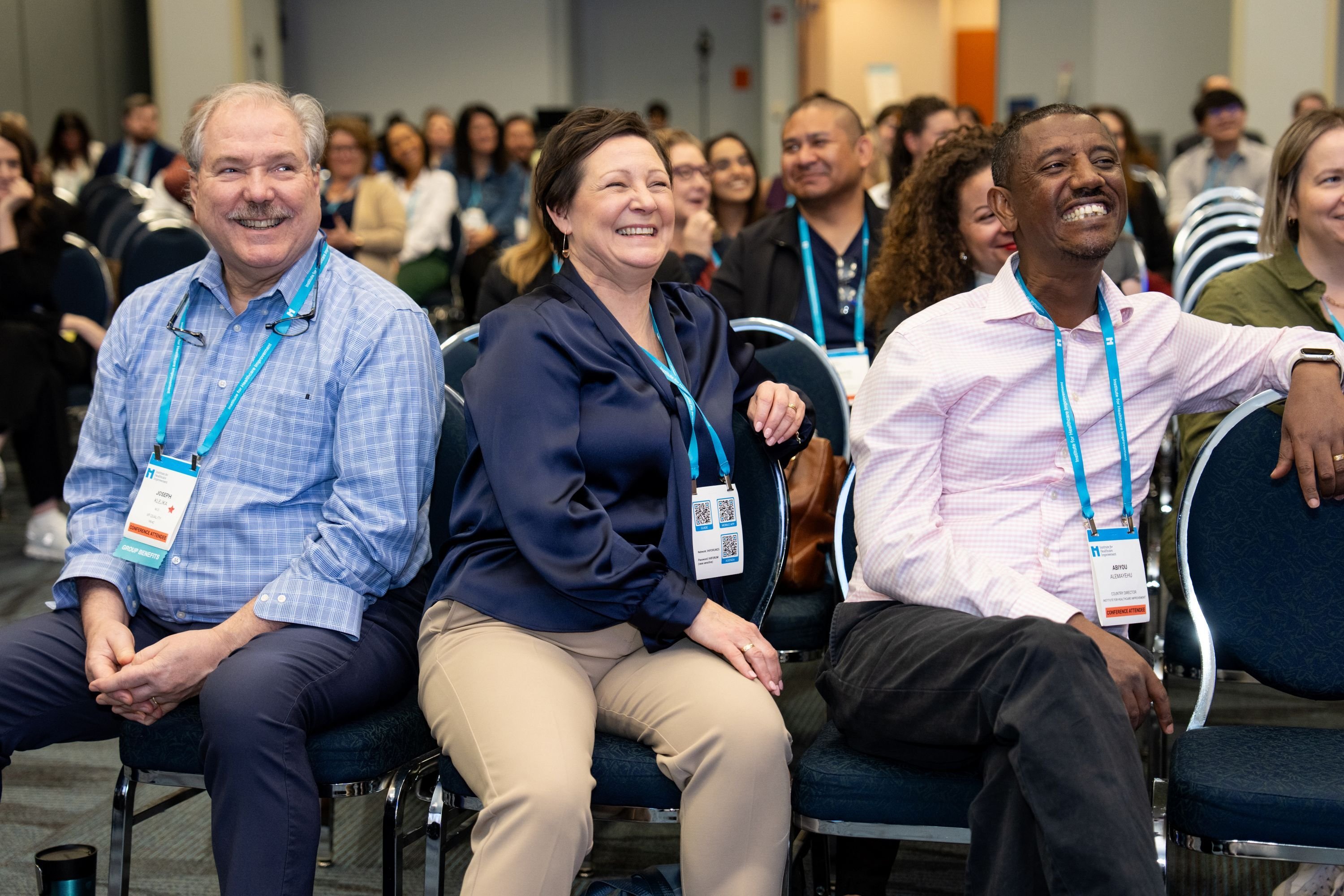 3 attendees attending a 2025 Forum session and smiling