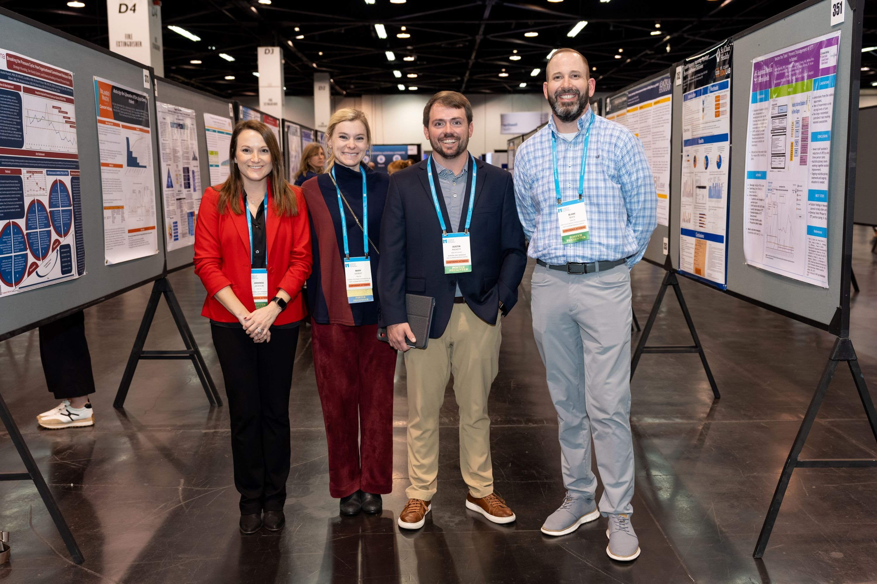 4 attendees taking a group photo in the Forum's poster hall