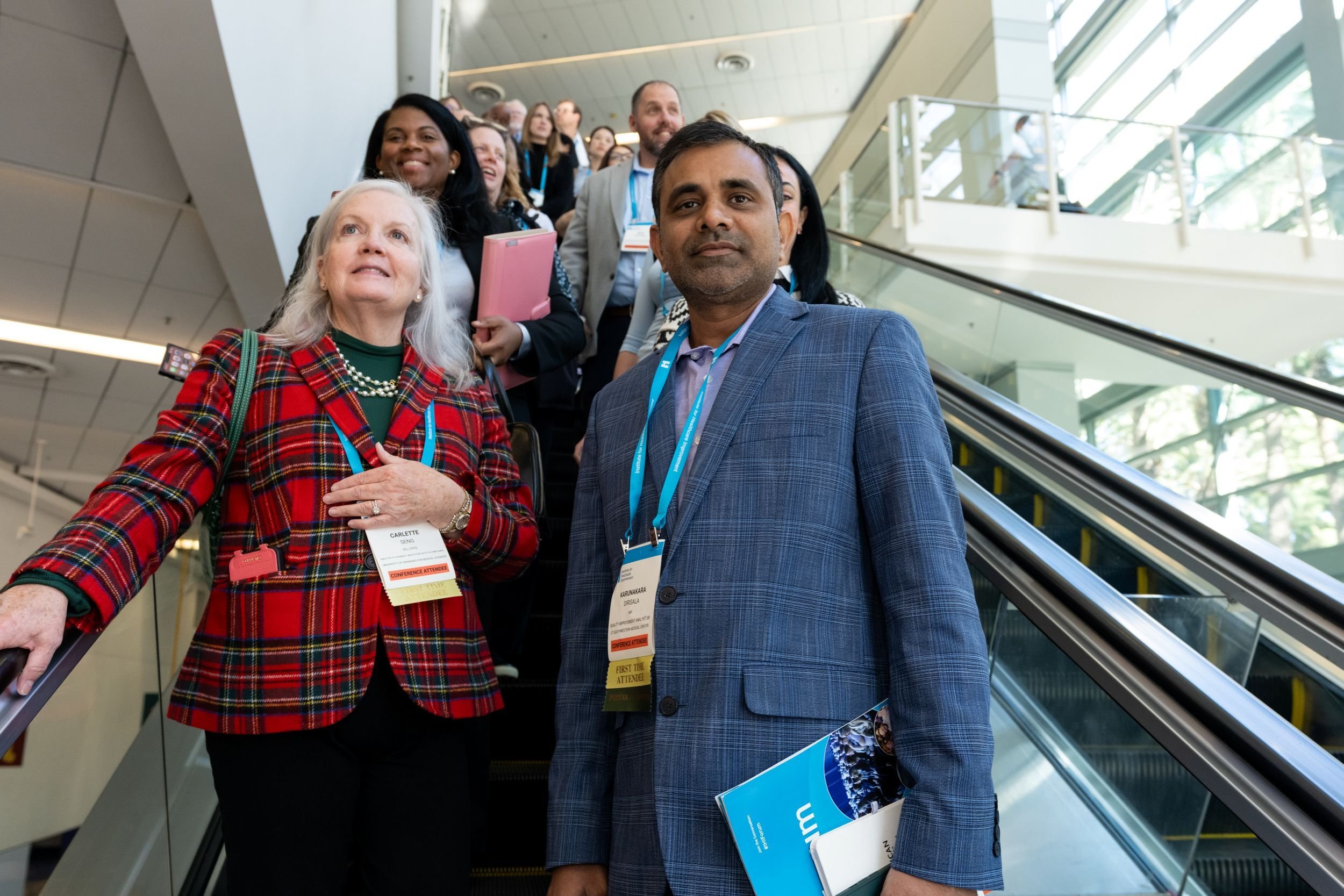 Attendees riding down an escalator at the 2025 IHI Forum